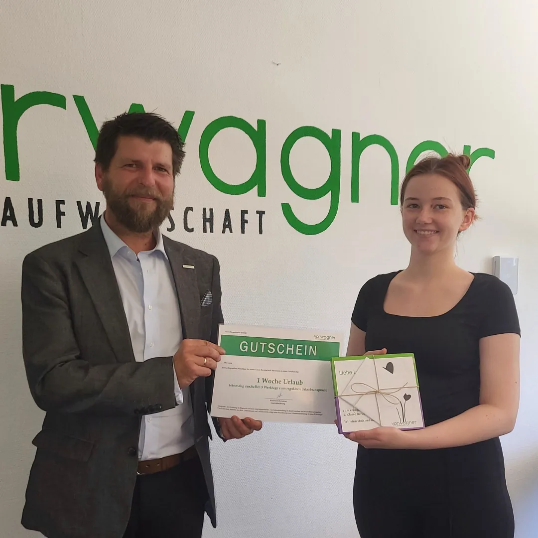 Vorwagner-Geschäftsführer Manfred Scherleitner gratuliert Lehrling Lena zum Berufsschulabschluss und überreicht einen Gutschein