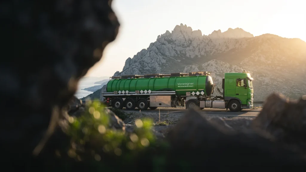 Grüner Vorwagner-Tankwagen auf einer Küstenstraße vor Bergen im Abendlicht